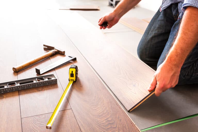 A man remodeling the bathroom floor tiles