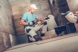 A worker doing the tiles for bathroom remodeling