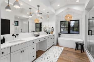 Wide bathroom with cozy bathtub and vanities with tops